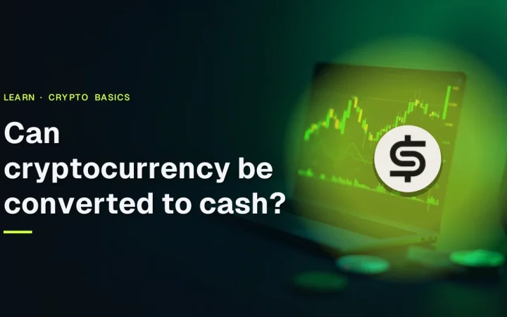Can cryptocurrency be converted to cash? title over a dark desk with a glowing terminal and blank coins.