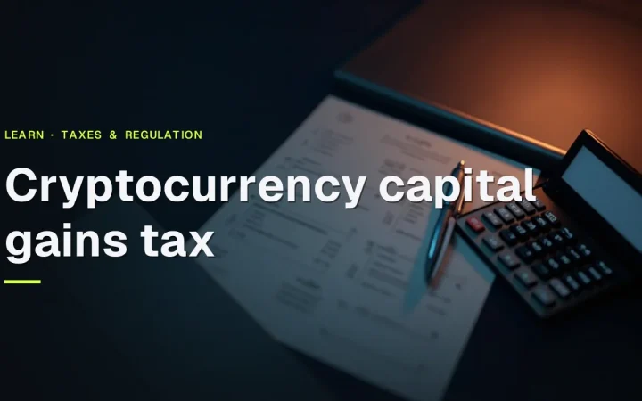 The title Cryptocurrency capital gains tax over blank tax forms, a calculator and a pen on a dark navy desk