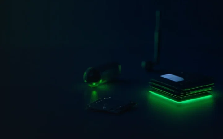 Un wallet, un terminal de paiement, des cartes et des accents vert lime lumineux sur un bureau bleu marine foncé.