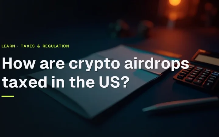 How are crypto airdrops taxed in the US? title over a dark navy background with a blank form, pen, and calculator on the right.
