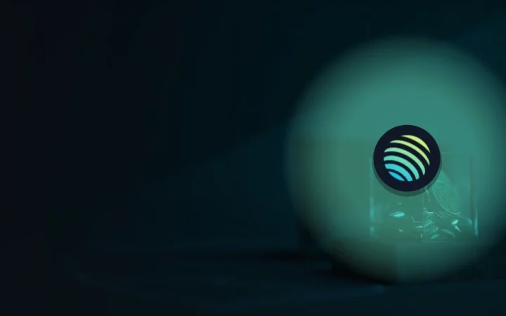 Jupiter-logoet over en glaskube med teal-farvede coins på en mørk navybaggrund.