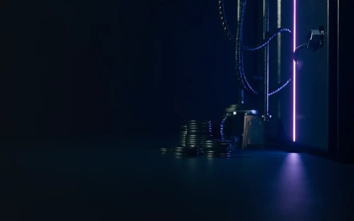 Une scène de coffre bleu marine foncé avec des piles de disques de pièces métalliques vierges et une lueur violette à droite, côté gauche vide.