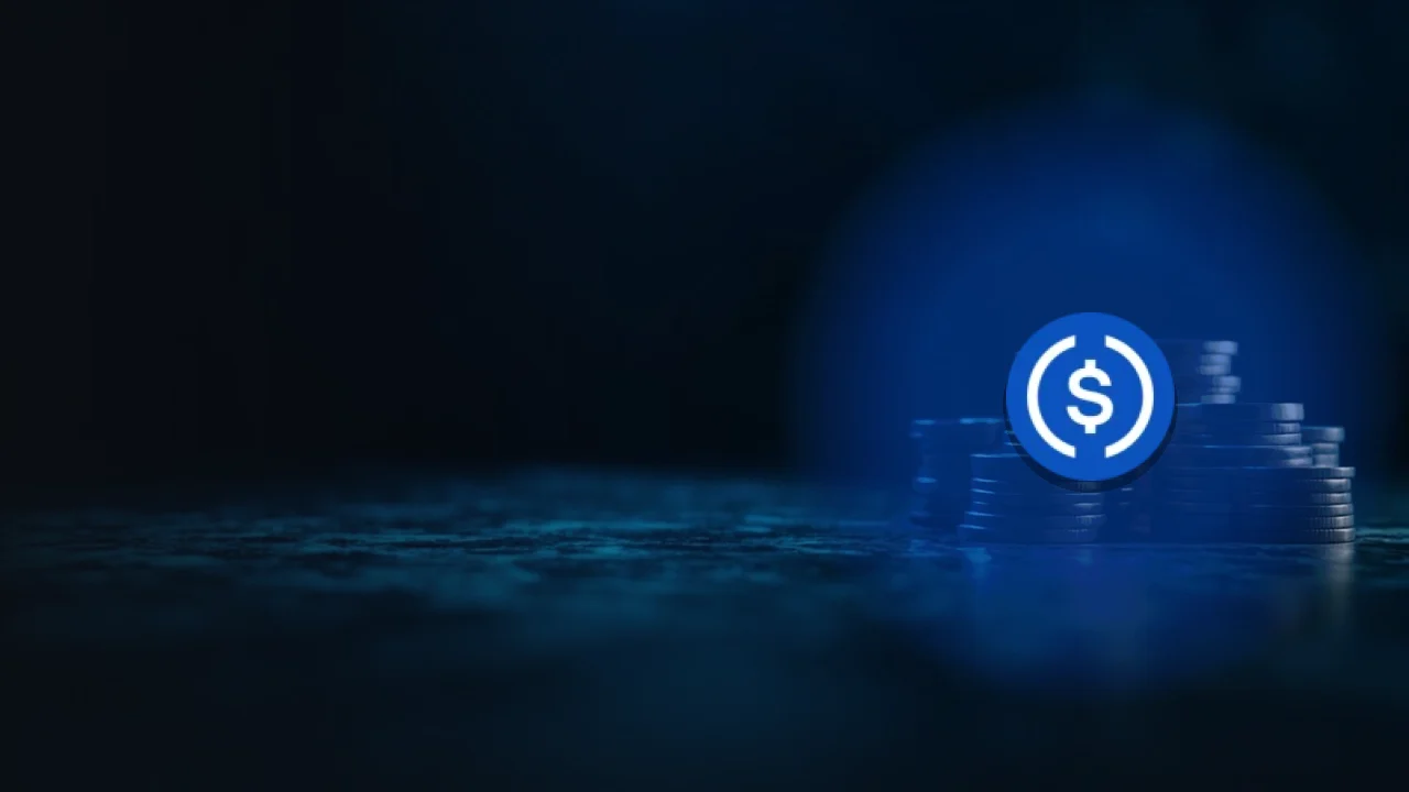 The USD Coin logo over stacks of blank coins in a dark blue vault.