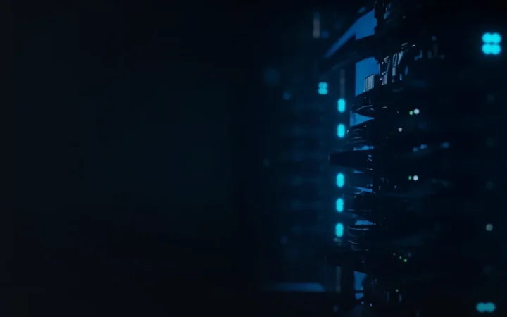 En mørk baggrund med glødende serverracks til højre.