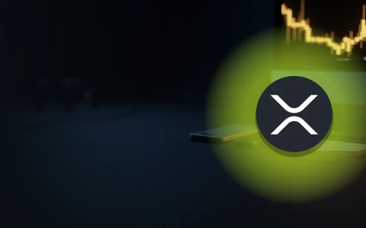 Ein dunkler Schreibtisch mit Telefon, Karte und Gold-Chart sowie dem XRP-Logo.