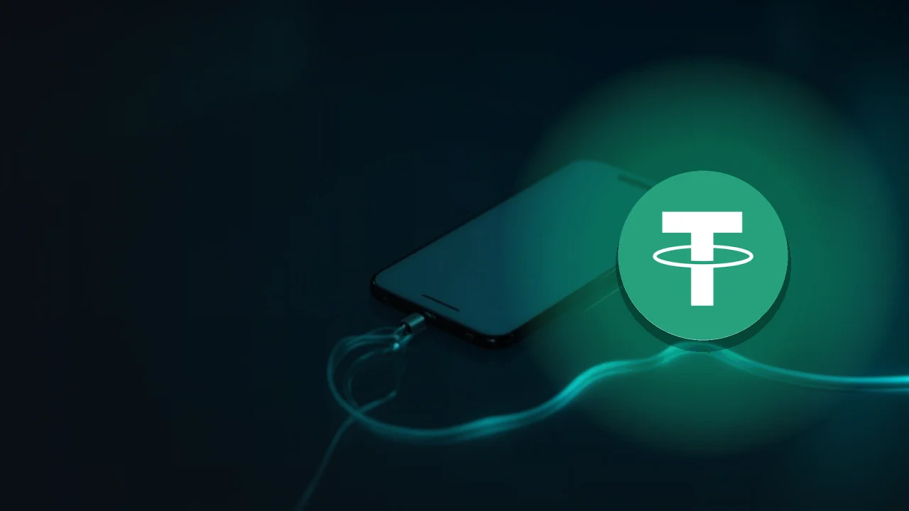 Le logo Tether sur un bureau bleu marine sombre avec un téléphone, des pièces et un câble turquoise.