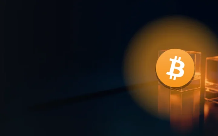 Bitcoin-logoet over en mørk navybaggrund med glasblokke forbundet af glødende orange lys.