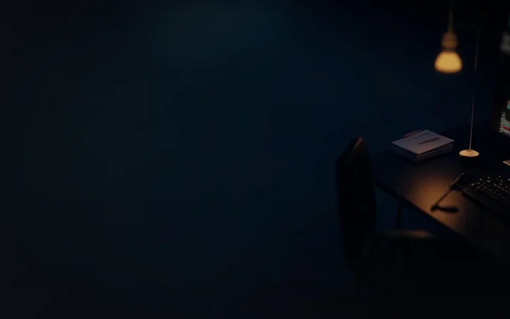 A dark navy desk with glowing gold abstract monitors and a blank notepad.
