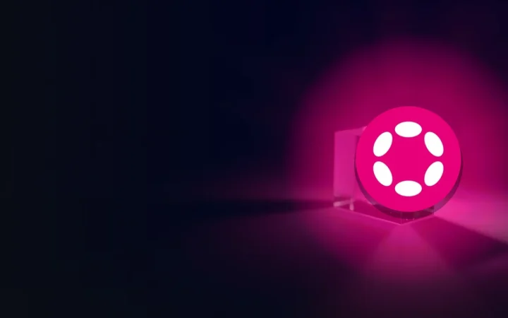어두운 남색 배경의 빛나는 유리 블록 위에 놓인 Polkadot 로고.