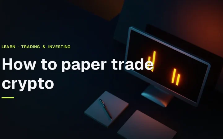 Titlen Sådan paper trader du crypto vises over en mørk skrivebordsscene med en blank skærm, notesbog og pen, oplyst i orange.