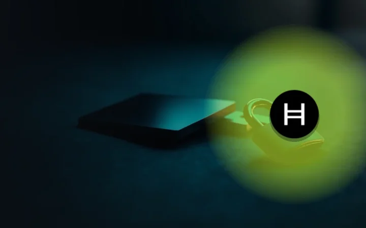 Hedera-logoet over en mørk scene med en hardware wallet, en stålplade og en hængelås.