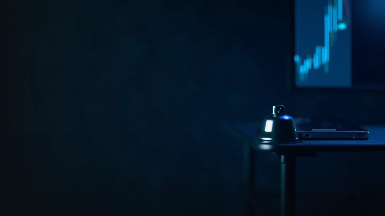A dark desk with a glowing blue price chart, a smartphone showing a bell icon, and a small silver bell, with the left side empty.