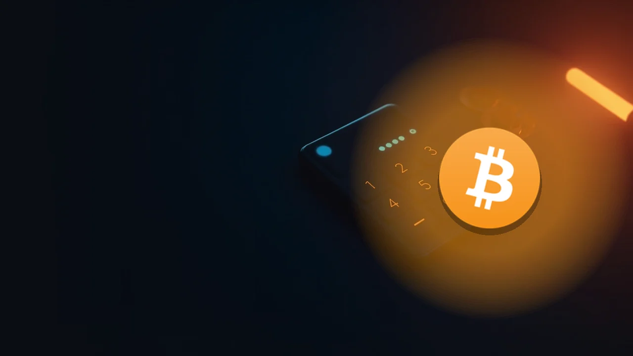 Bitcoin-logotypen över en mörkblå skrivbordsyta med en elegant kalkylatorliknande enhet vars tomma display lyser svagt.