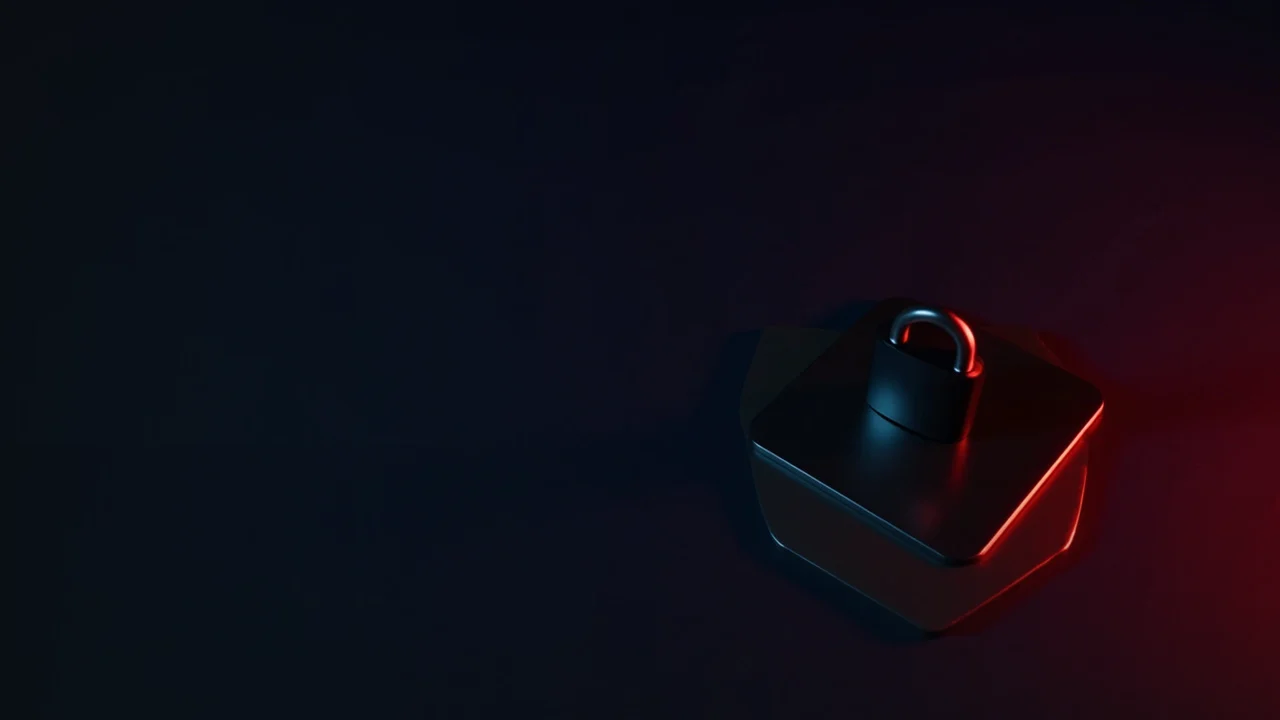 Et mørkt skrivebord med en hardware wallet, stålplade og hængelås i rød og marineblå.