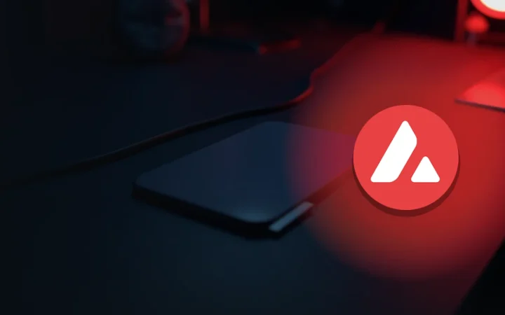 The Avalanche logo over a dark desk with a blank-screen device, coiled cable and steel plate lit by red glow.