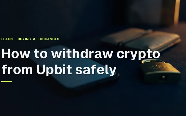 어두운 책상 위에 휴대폰, 하드웨어 지갑, 자물쇠가 놓여 있고, 그 위에 Upbit에서 암호화폐를 안전하게 출금하는 방법이라는 제목이 있습니다.