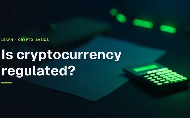 Der Titel Is cryptocurrency regulated? über einem dunklen Schreibtisch mit einem leuchtenden Taschenrechner, leeren Formularen und einem Ordner in limettengrünem Licht.