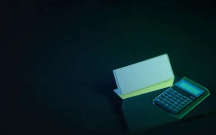 Un escritorio oscuro con nóminas en blanco, una carpeta y una calculadora iluminados en verde lima.