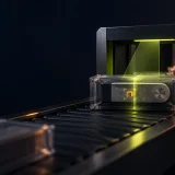 A generic hardware wallet package is scanned while one foreign component is revealed.