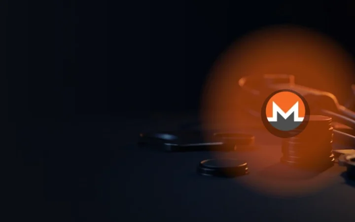 Monero-logoet over mørke metalmønter, en stålplade og en hængelås oplyst i orange.
