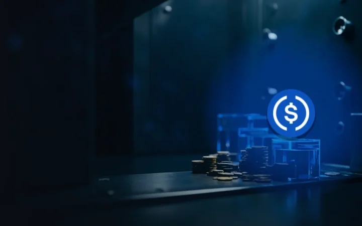 The USD Coin logo over a dark navy vault with stacks of blank coins and glass cubes lit by blue accents, leaving the left half empty.