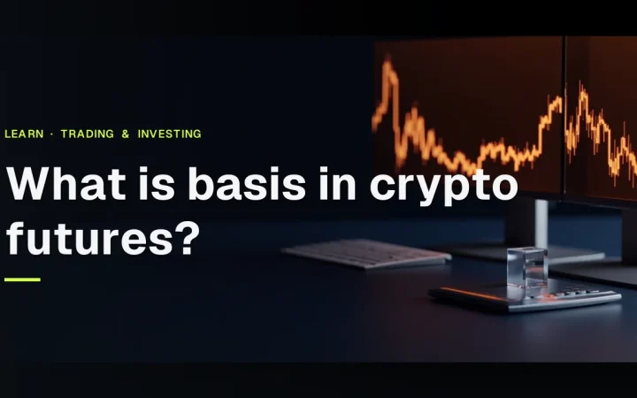 Titlen 'What is basis in crypto futures?' over et mørkt skrivebord med glødende orange diagrambjælker, en tom lommeregner og en glasblok.