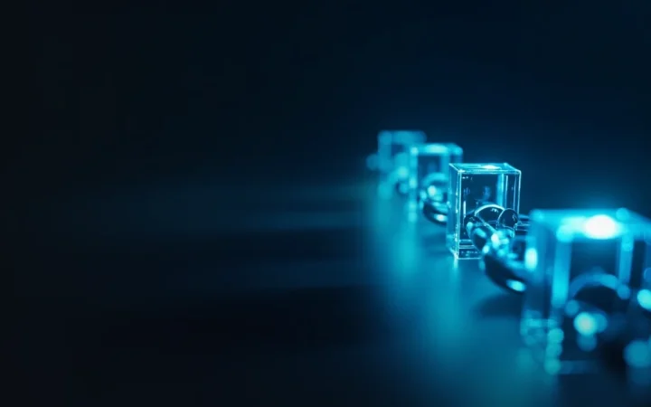 Glødende cyan glasblokke forbundet af lys på en mørk navy baggrund.