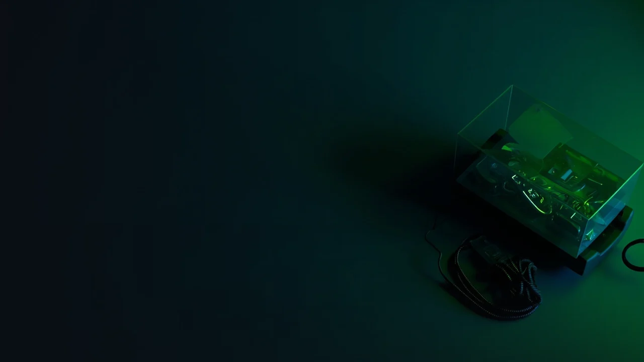 Et mørkt skrivebord med en kortterminal, tomme tokens og kabler oplyst i limegrøn.