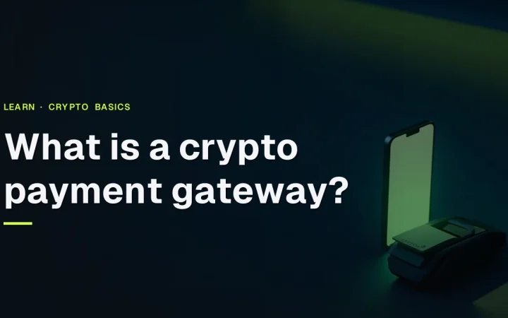 Titlen What is a crypto payment gateway over et mørkt skrivebord med en lysende kortterminal og en tom telefon.