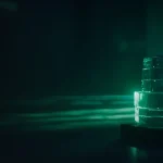 En mørk navyblå baggrund med glødende smaragdgrønne glasblokke forbundet af lyse linjer.