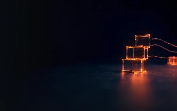 A dark navy background with glowing orange glass cubes and cables on the right.