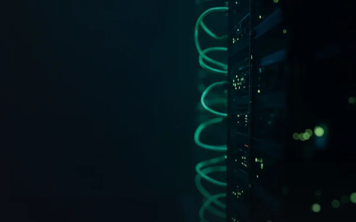 A dark background of glowing green server racks and light nodes.