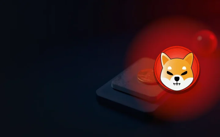 Shiba Inu-logotypen över en mörkblå skrivbordsscen med ett tomt kopparmynt och en stålplatta.