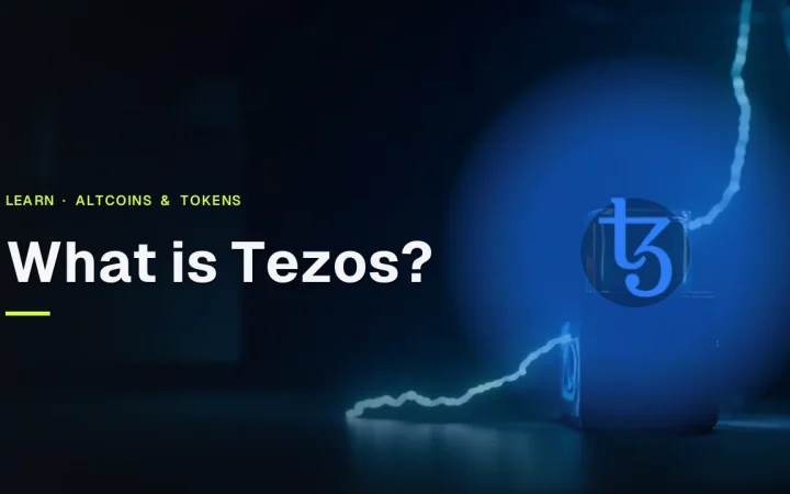 The title What is Tezos and the Tezos logo over a dark navy desk with glass blocks, blue light trails and a blank metal device.