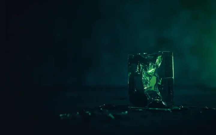 A dark navy background with a broken glass chain, a cracked padlock and scattered blank coins on the right.